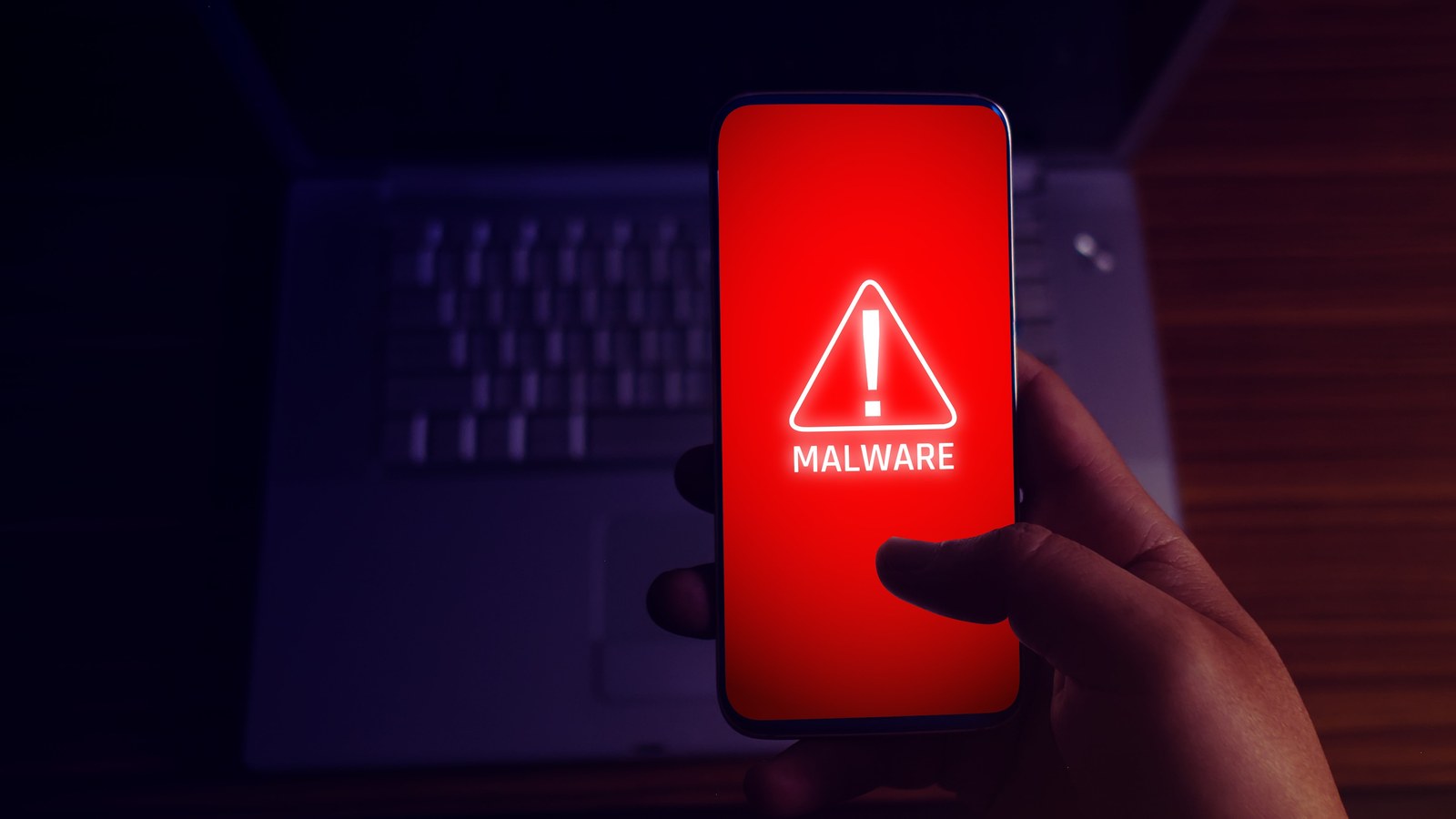 A malware alert on a phone screen in a darkened room