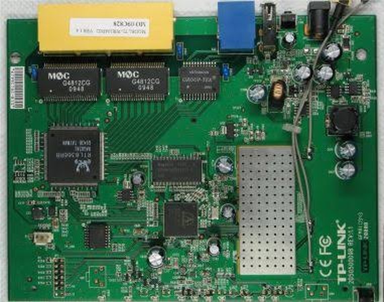 The TP-Link router board with its SoC and flash exposed