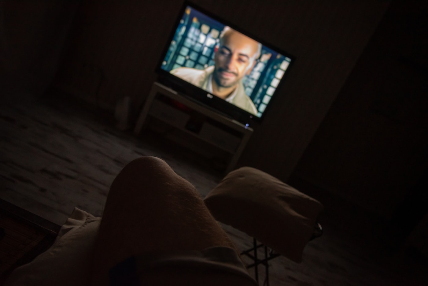 A flat-screen TV glowing in a dark room